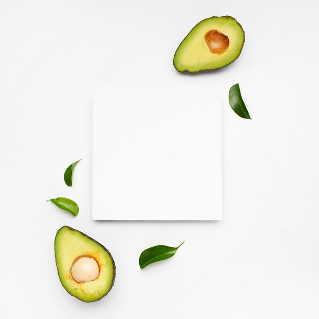 Nice composition of avocado on white surface with a frame for text