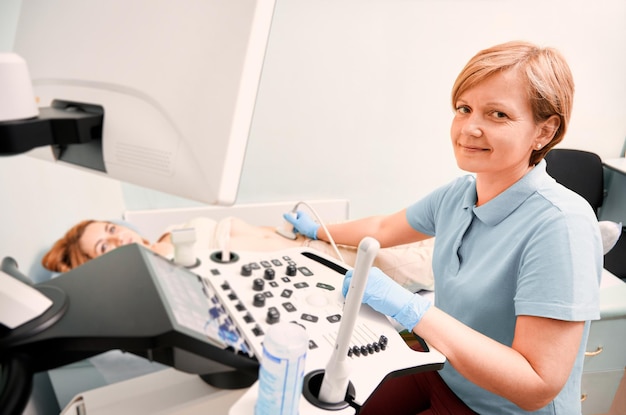 Бесплатное фото Хорошая женщина-врач, выполняющая ультразвуковую процедуру в клинике