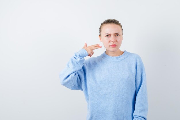 The nice girl is showing she is shooting herself on white background