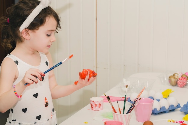 Nice girl painting egg with red