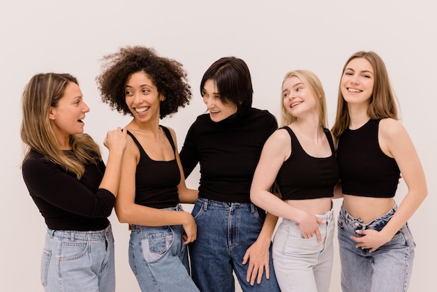 Nice interracial women of different ages in casual clothes communicate standing on white background