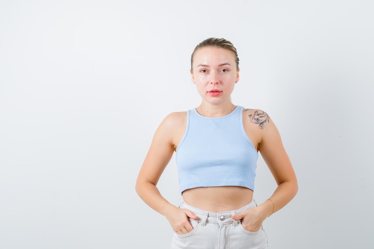 無料Photo 素敵な女性は彼女の手を彼女に置き、白い背景の上のカメラを見て