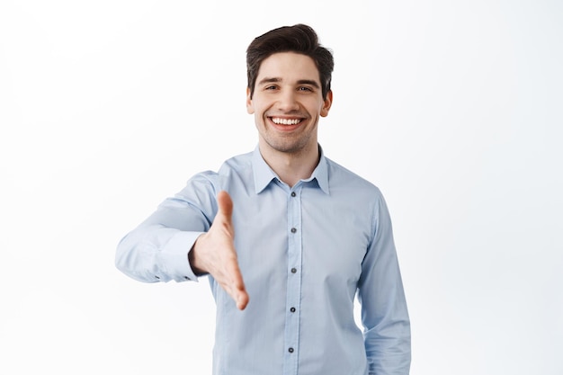 Nice to meet you. Handsome businessman stretch out hand for handshake, greeting business partner, corporate welcome, standing over white background