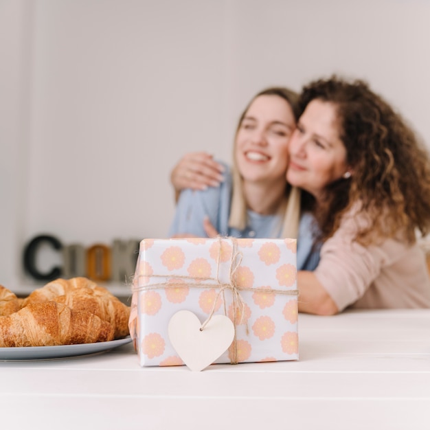 Nice present near hugging mother and daughter