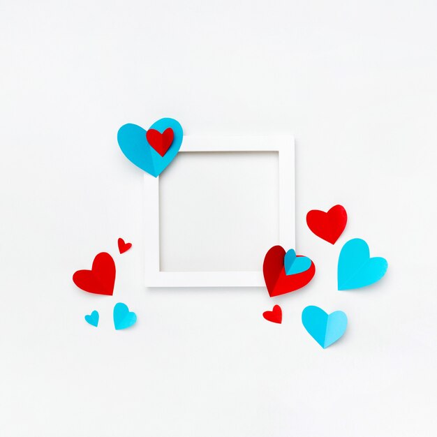 Nice square white frame with copyspace for text on white background decorated with handmade paper hearts