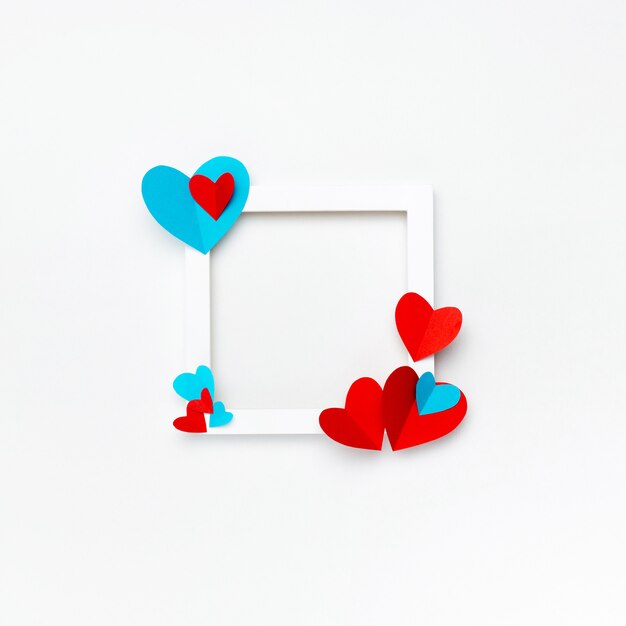 Nice square white frame with copyspace for text on white background decorated with handmade paper hearts