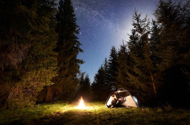 Night camping in mountains under starry sky and milky way