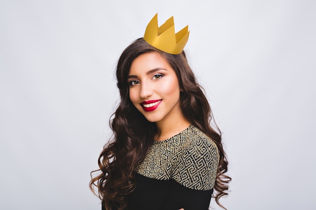 Free photo night party, birthday, new year celebration. portrait joyful pretty girl with long curly brunette hair in yellow crown on white space