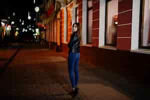 Free photo night portrait of girl model wear on glasses jeans and leather jacket with backpack against city streets