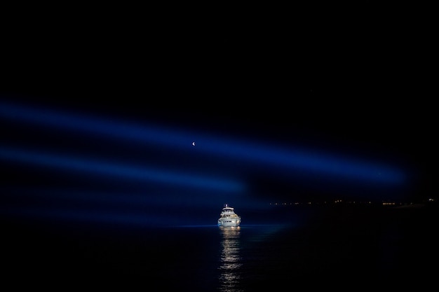 Ночное небо над белой яхтой в море