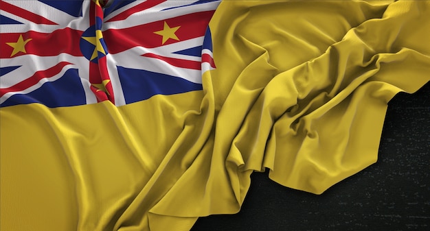 Free photo niue flag wrinkled on dark background 3d render