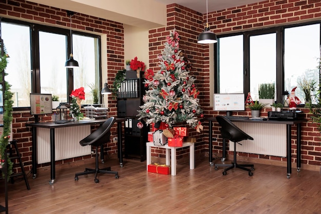 Нет людей в пустом офисе с праздничным декором, елкой и сезонными праздничными украшениями, чтобы отпраздновать зимнюю традицию на рабочем месте корпоративного стартапа. Рождественские украшения сезона.