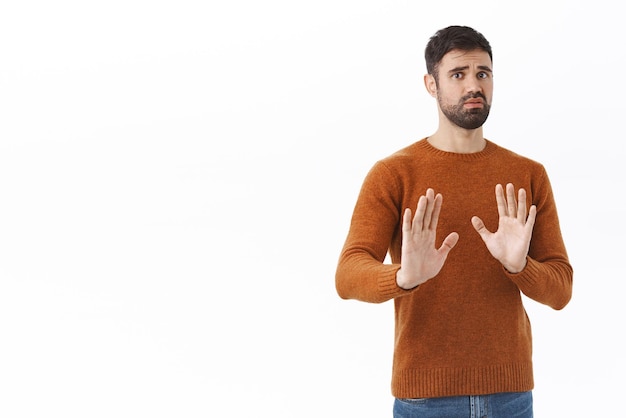 Free photo no thank you portrait of concerned and worried handsome bearded man shaking hands in refusal avoid something bad unwilling to participate reject and deny dont like offer copy space