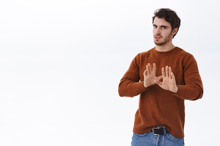 無料Photo いいえ、結構です。気が進まない、不機嫌な若いハンサムな男が後退し、嫌悪感と嫌悪感から顔をしかめ、握手