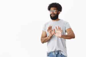 Free photo no thanks i pass not interested dissatisfied african american male customer with beard and tattoos grimacing in dislike waving in negative answer raising palms in refusal and rejection gesture