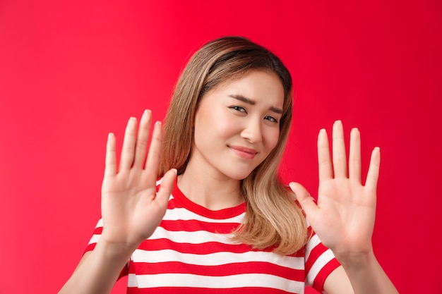 No thanks i pass reluctant lazy cute asian modern girl show hands block rejection gesture smirking d...