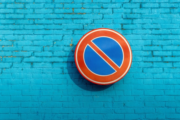 No waiting sign on a blue brick wall