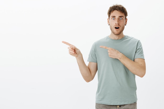 No way, can you believe this. Shocked speechless european male model in t-shirt, dropping jaw and staring with popped eyes while being surprised and amazed