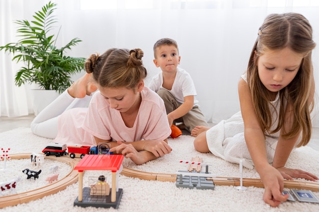 Foto gratuita bambini non binari che giocano con il gioco delle automobili a casa