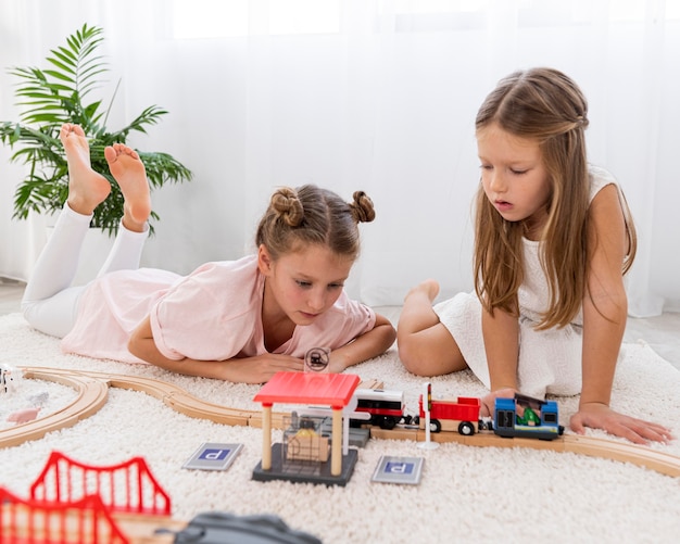 Free photo non-binary children playing with cars game indoors