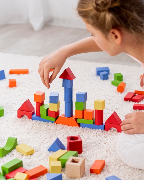 Non binary kid playing with a colorful game at home