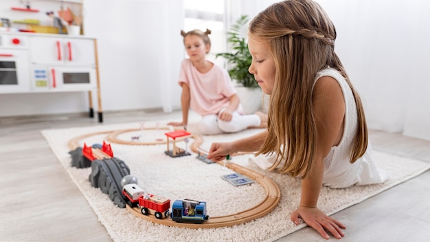 Foto gratuita bambini non binari che giocano con un gioco di auto