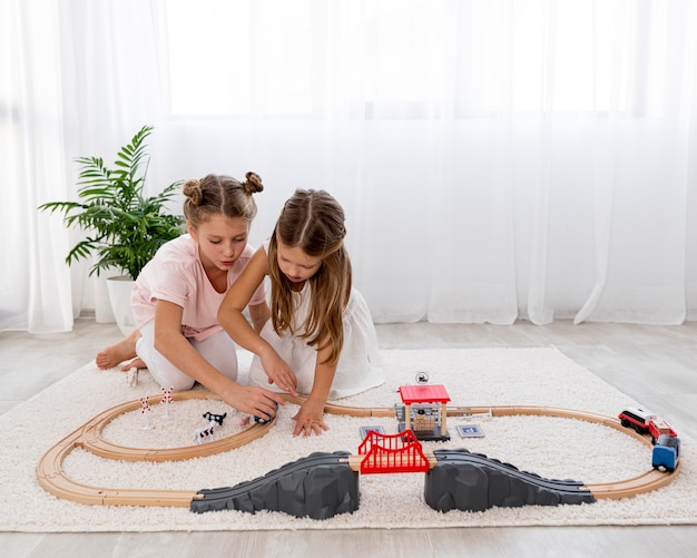 Foto gratuita bambini non binari che giocano con le macchine a casa