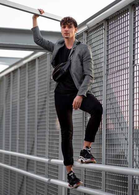 Non binary person posing on a metallic fence