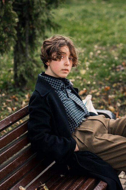 Non binary person sitting on a bench