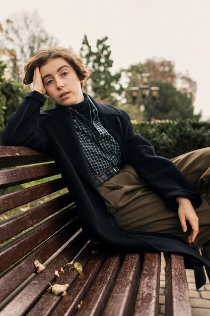 non binary person sitting on the bench