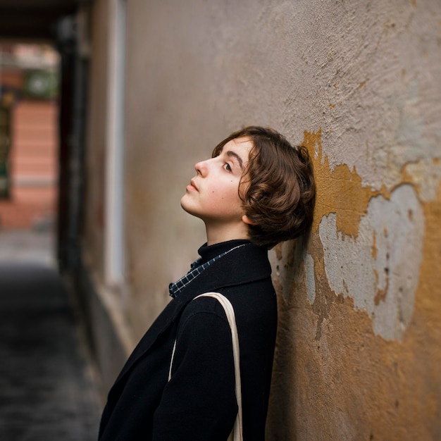 Foto gratuita persona non binaria con la testa su un muro