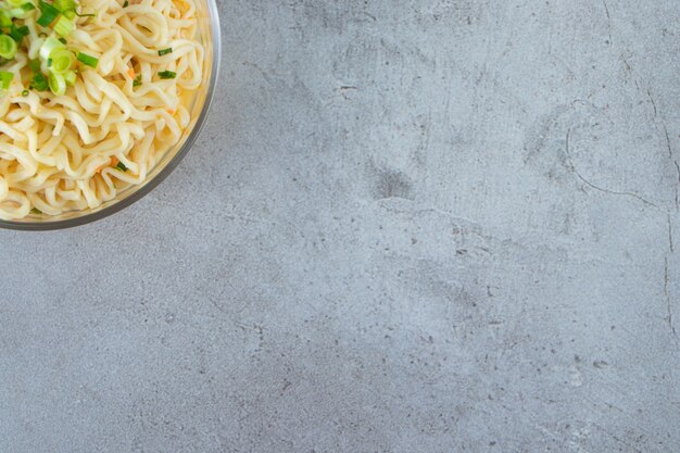 Noodle in a glass bowl, on the marble background. 