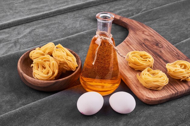 Noodle rolls with ingredients on a wooden black board.