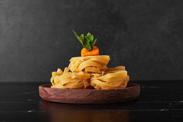 Noodles served with parsley and carrot