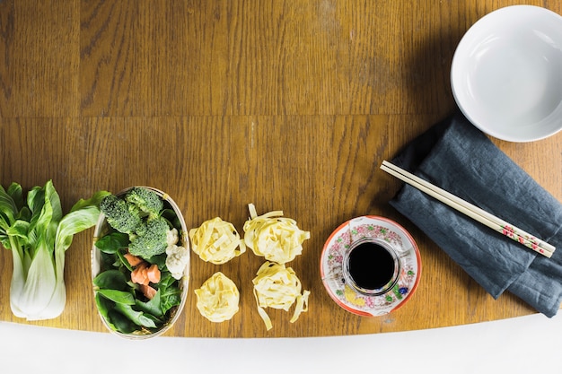 Noodles and vegetables near soy sauce