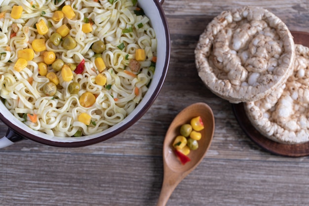 Noodles with corns, peas and round bread crusts 