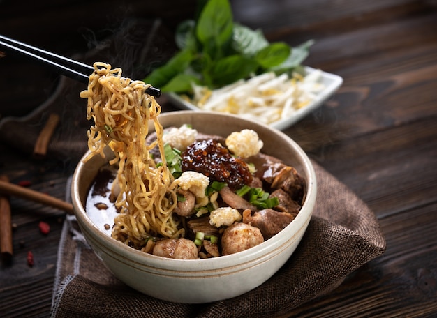 Noodles with pork and pork balls, chilli paste with soup Thai style and vegetable. Boat Noodles. Selective focus