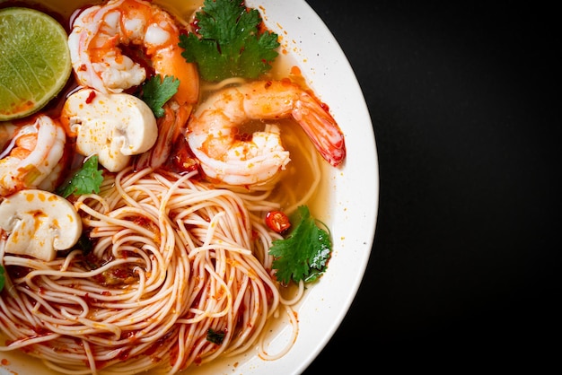 白いボウルにスパイシーなスープとエビが入った麺（トムヤムクン）-アジア料理スタイル Premium写真