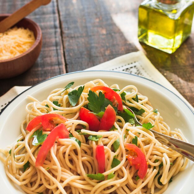 Noodles with tomatoes and coriander leaves on plate