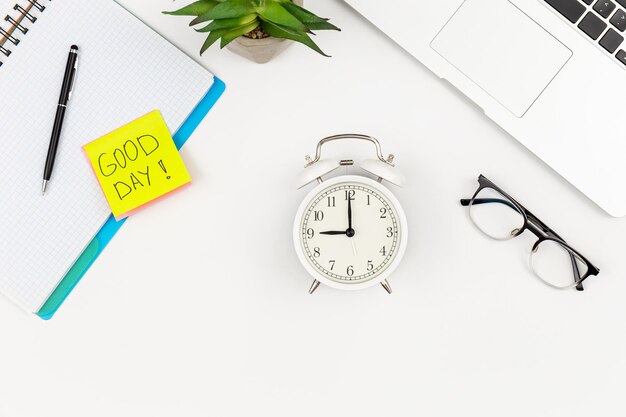 Notebook an alarm clock laptop and a paper reminder on a white background