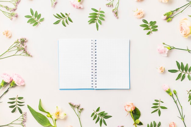 Notebook amidst flowers and leaves