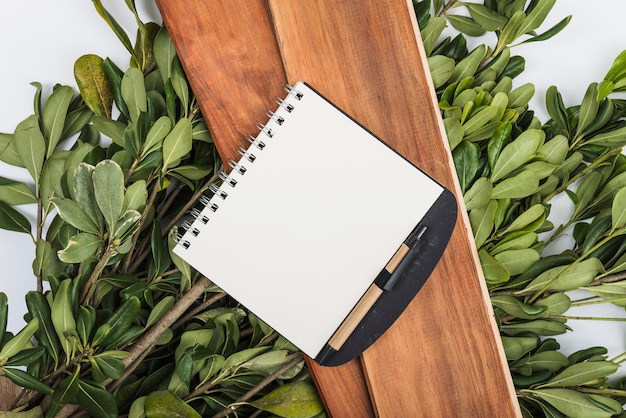 Free photo notebook on boards and plants