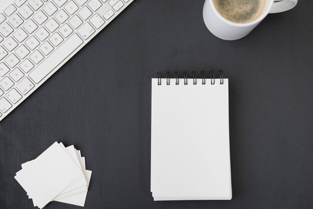 Notebook, business card, coffee and keyboard