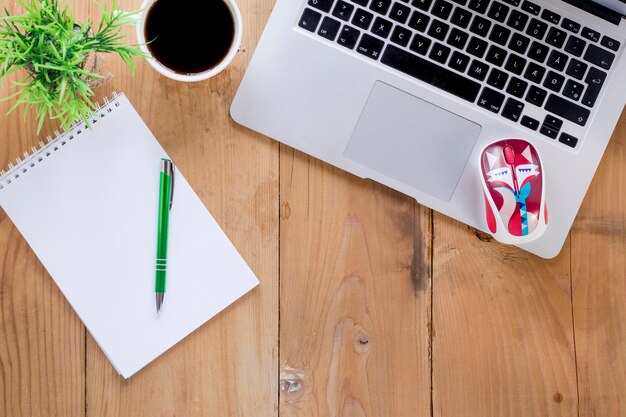 Notebook and coffee near stationary on wooden table