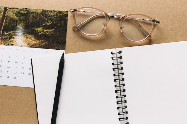 Notebook and glasses near calendar