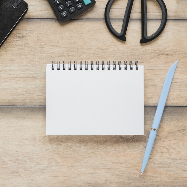 Free photo notebook near calculator and scissors on table