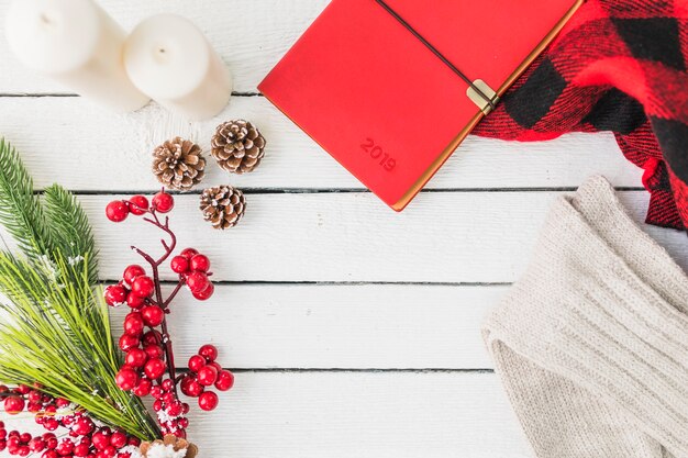 Notebook near clothes and fir twigs 