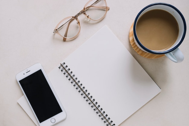 Notebook near smartphone and coffee