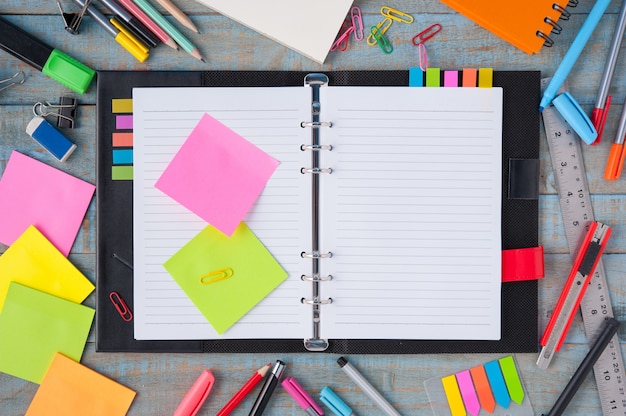 Notebook paper and school or office tools on vintage wood table 