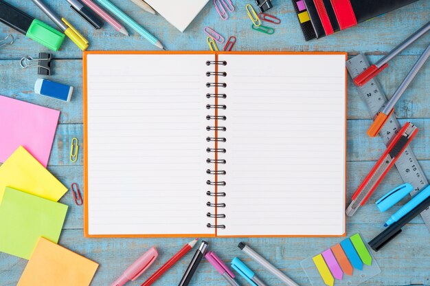 Notebook paper and school or office tools on vintage wood table 